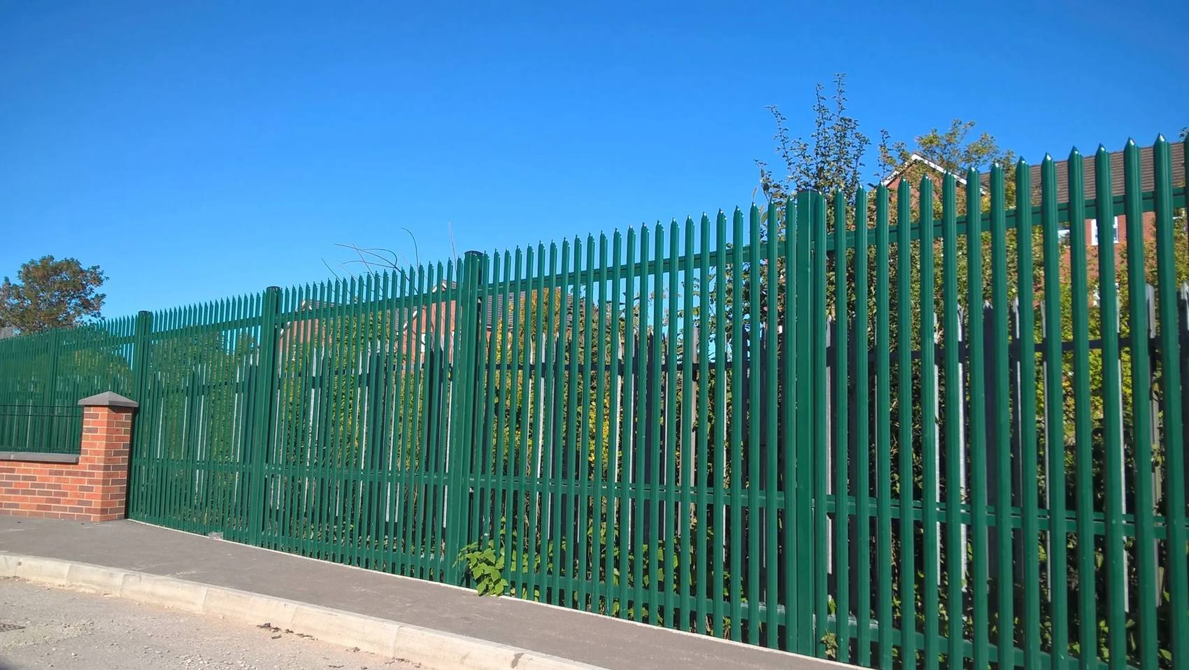 Green powder-coated palisade fence along a roadside